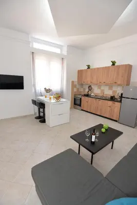a living room with a table and a kitchen at Sotirias House in Rhodes Town