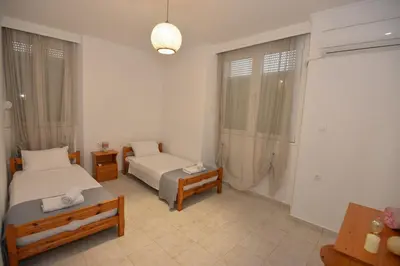 a hotel room with two beds and a table at Sotirias House in Rhodes Town