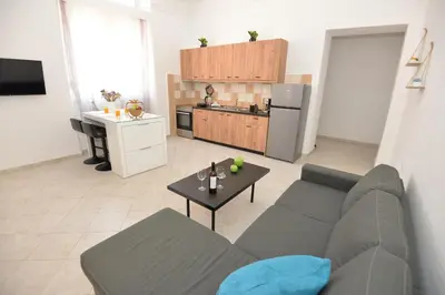 a living room with a couch and a table and a kitchen at Sotirias House in Rhodes Town