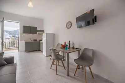 a living room with a table and chairs and a kitchen at Rhodes Archaggelos Nests - Fully Equipped Getaways in Archangelos