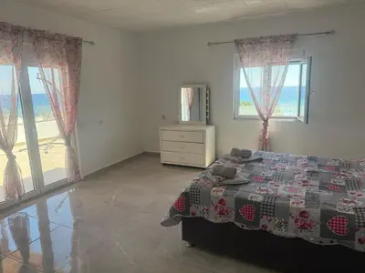 a bedroom with a bed and two windows at Little Paradis in Archangelos