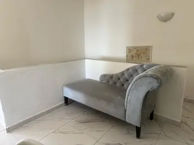 a gray couch sitting in a room with a wall at Little Paradis in Archangelos