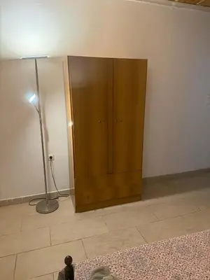 a wooden cabinet in the corner of a room with a lamp at Little Paradis in Archangelos