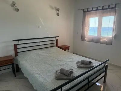 a bedroom with a bed with towels and a window at Little Paradis in Archangelos