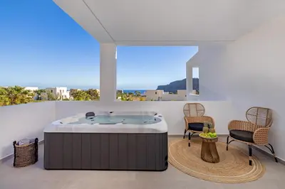 a hot tub in a room with two chairs and a window at Luxury Villa Amani Retreat in Líndos