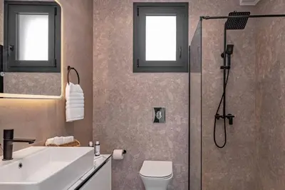 a bathroom with a shower and a toilet and a sink at Luxury Villa Amani Retreat in Líndos