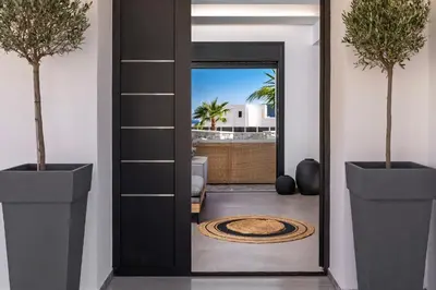 a door leading into a living room with two potted plants at Luxury Villa Amani Retreat in Líndos