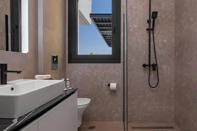a bathroom with a shower and a sink and a toilet at Luxury Villa Amani Retreat in Líndos