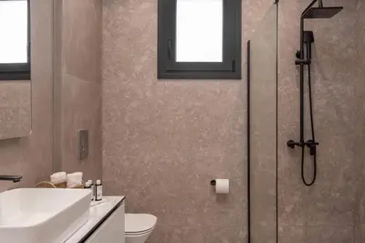 a bathroom with a shower and a sink and a toilet at Luxury Villa Amani Retreat in Líndos