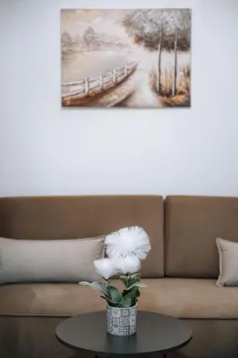 a vase with white flowers on a table in front of a couch at ILIADA Boutique Rooms in Faliraki