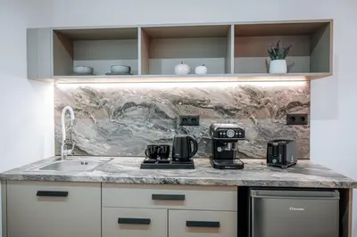 a kitchen counter with two coffee makers and a sink at ILIADA Boutique Rooms in Faliraki