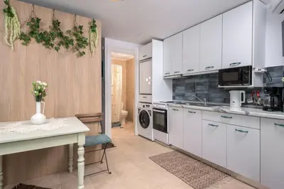 a kitchen with white cabinets and a table with flowers at Malonas Village house in Malona Village
