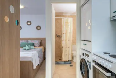a small room with a bed and a kitchen at Malonas Village house in Malona Village