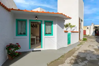 a white house with a green door and windows at Malonas Village house in Malona Village