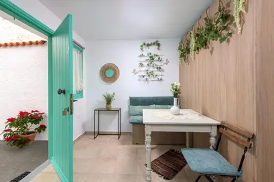 a room with a table and a green door at Malonas Village house in Malona Village