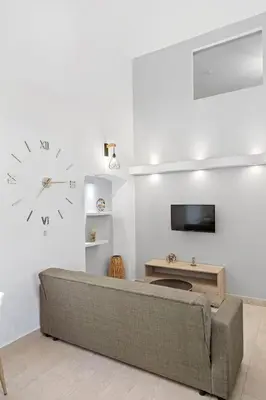 a living room with a couch and a clock on the wall at VastekaHouse3 in Haraki