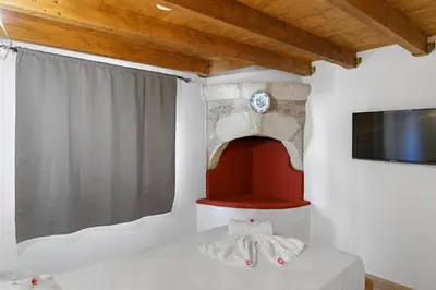 a room with a bed with a clock on the wall at VastekaHouse3 in Haraki