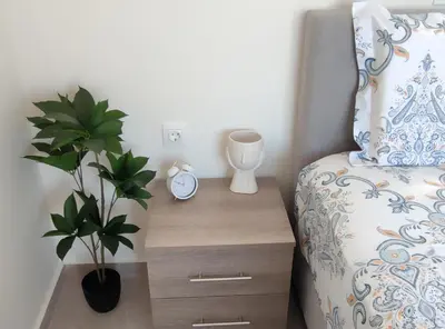 a bedroom with a bed and a night stand with a plant at Villa with 2 bedrooms - 2 bathrooms - Private pool in Haraki