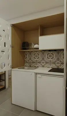 a kitchen with white cabinets and a white refrigerator at Prasonisi Lighthouse Studios in Prasonisi