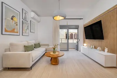 a living room with a white couch and a tv at Rhodes center Santa Maria in Rhodes Town