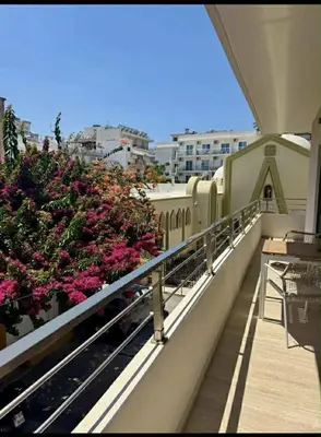 a balcony of a building with pink flowers on it at Rhodes center Santa Maria in Rhodes Town