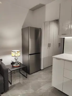 a kitchen with a refrigerator and a table with a lamp at Rhodes City Haven in Rhodes Town