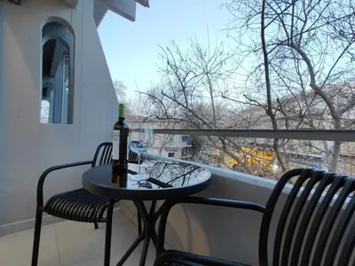 a table with a bottle of wine and two chairs on a balcony at Rhodes City Haven in Rhodes Town