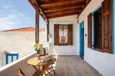a balcony with a table and chairs on a house at Isminis Villa in Halki