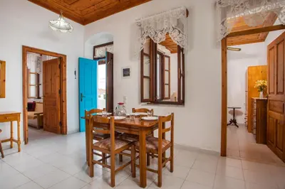 a dining room with a wooden table and chairs at Isminis Villa in Halki