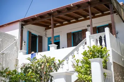 a house with white stairs and blue windows at Isminis Villa in Halki