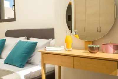 a bedroom with a bed and a table with a mirror at Villa Laila in Ialyssos