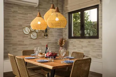 a dining room with a wooden table with chairs at Villa Laila in Ialyssos