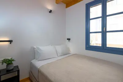 a white bedroom with a bed and a window at Villa fiore in Rhodes Town