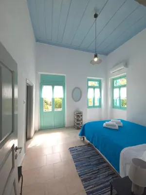 a bedroom with a blue bed and a blue door at Symi Fos House - Harbour View in Symi