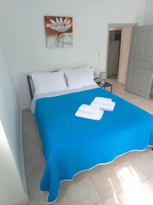 a blue bed in a white room with towels on it at Symi Fos House - Harbour View in Symi