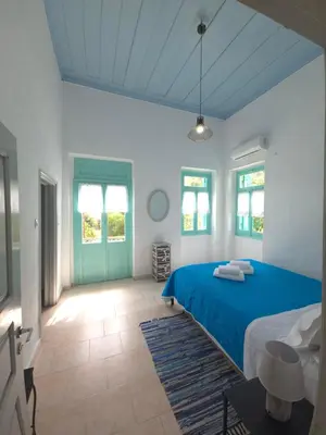 a bedroom with a blue bed and a blue door at Symi Fos House - Harbour View in Symi