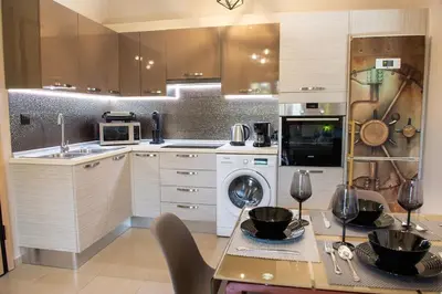 a kitchen with white cabinets and a table with bowls on it at Cozy Spot in Ixia