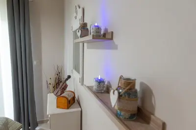 a room with two shelves on the wall with candles at Cozy Spot in Ixia