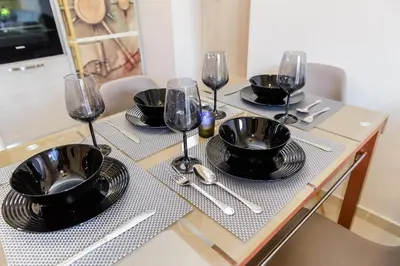a table with black plates and wine glasses on it at Cozy Spot in Ixia
