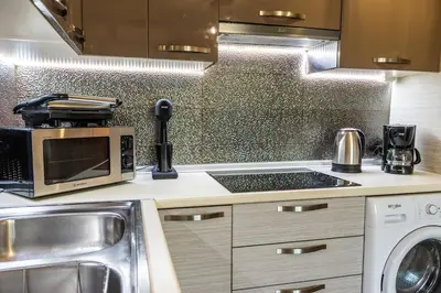 a kitchen with a stove top oven next to a sink at Cozy Spot in Ixia