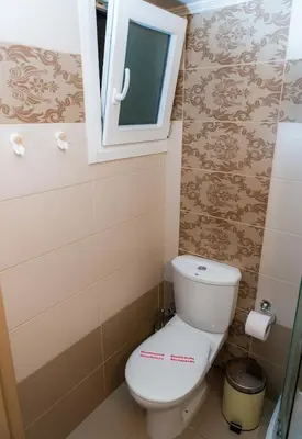 a small bathroom with a toilet and a window at Cozy Spot in Ixia