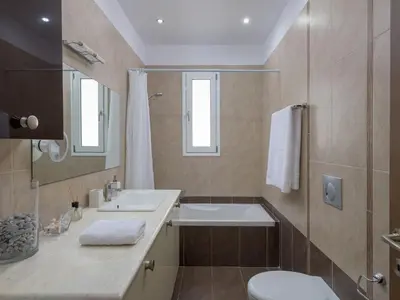a bathroom with a sink and a toilet and a mirror at Holiday Home Liebevoll ausgestattetes Haus in ruhiger Lage mit beheiztem Pool und Meerblick by Interhome in Gennadi