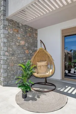 a hanging chair in a room with a plant at Holiday Home Emerald Estate by Interhome in Asgourou