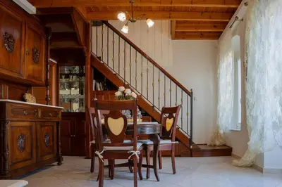 a dining room with a table and chairs and a staircase at Hermes Traditional house in Gialos in Symi