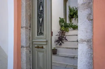 a door to a building with potted plants on the stairs at Hermes Traditional house in Gialos in Symi