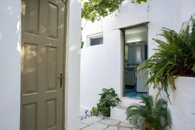 a door leading into a white house with plants at Hermes Traditional house in Gialos in Symi