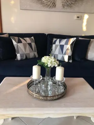 a coffee table with a vase of flowers and candles at Hermes Traditional house in Gialos in Symi