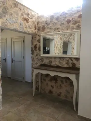 a living room with a mirror and a fireplace at Eirēnē house Afantou in Afantou