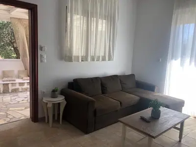 a living room with a brown couch and a table at Eirēnē house Afantou in Afantou