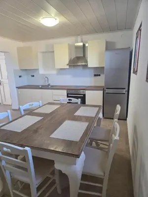 a kitchen with a table and chairs and a refrigerator at Eirēnē house Afantou in Afantou